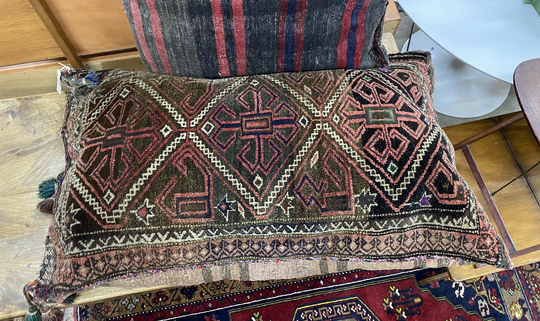 Two Afghan carpet cushions, larger 110 x 68cm